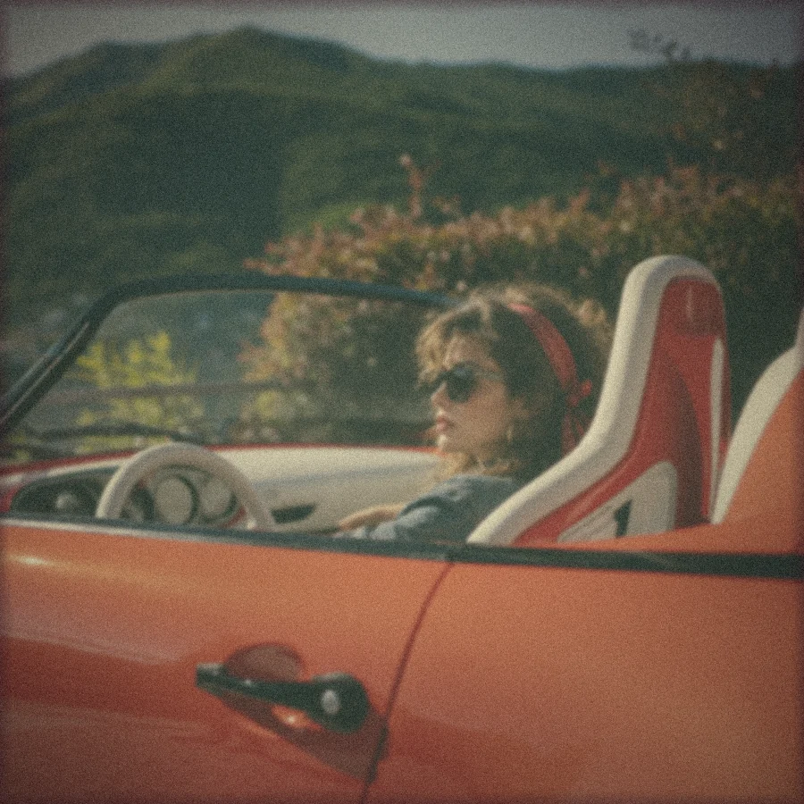Polaroid: a driver in sunglasses and a red bandana in the open Funkster, green hills behind